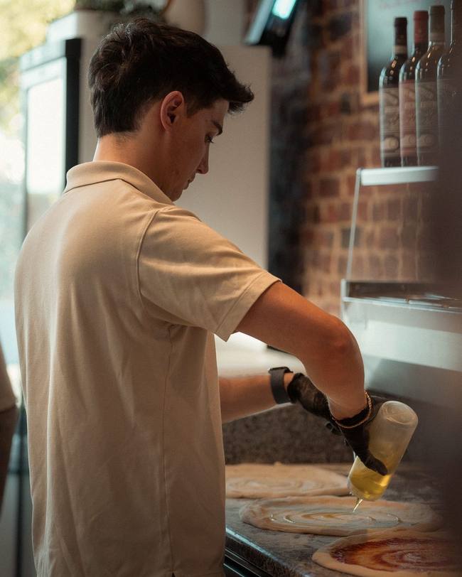 Finition à l'huile d'olive d'une pizza chez Pizz'Ath